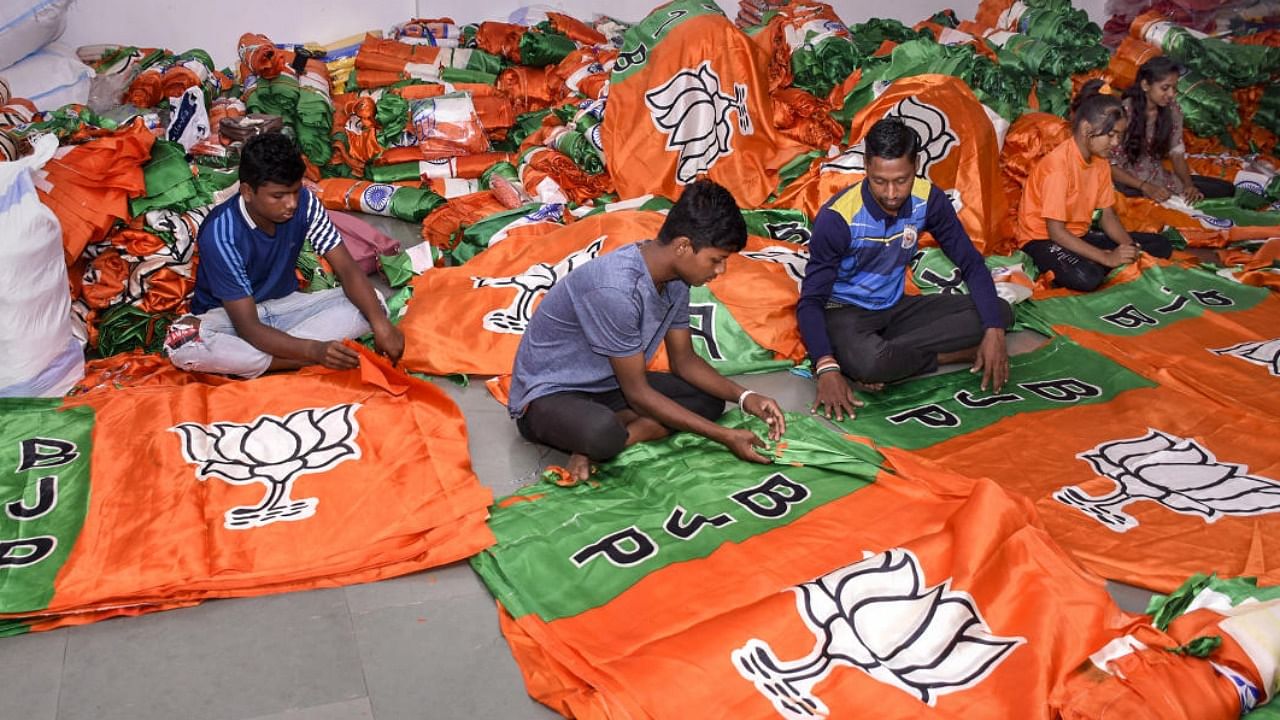 Workers prepare BJP party flags ahead of the Gujarat Assembly elections. Credit: PTI Photo