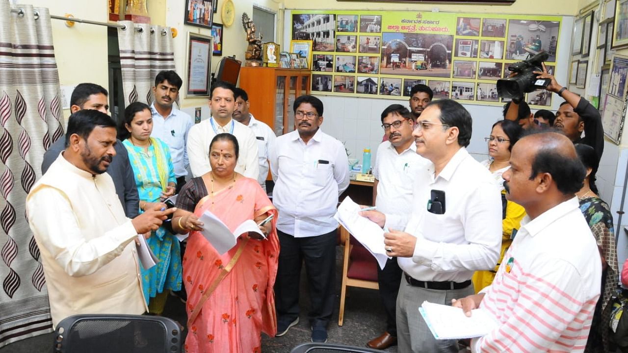 Karnataka State Commission for Protection of Child Rights president K Naganna Gowda interacts with staff of the district hospital in Tumakuru on Friday. District surgeon Dr Veena and Women and Child Development department deputy director Sridhar look on. Credit: DH Photo