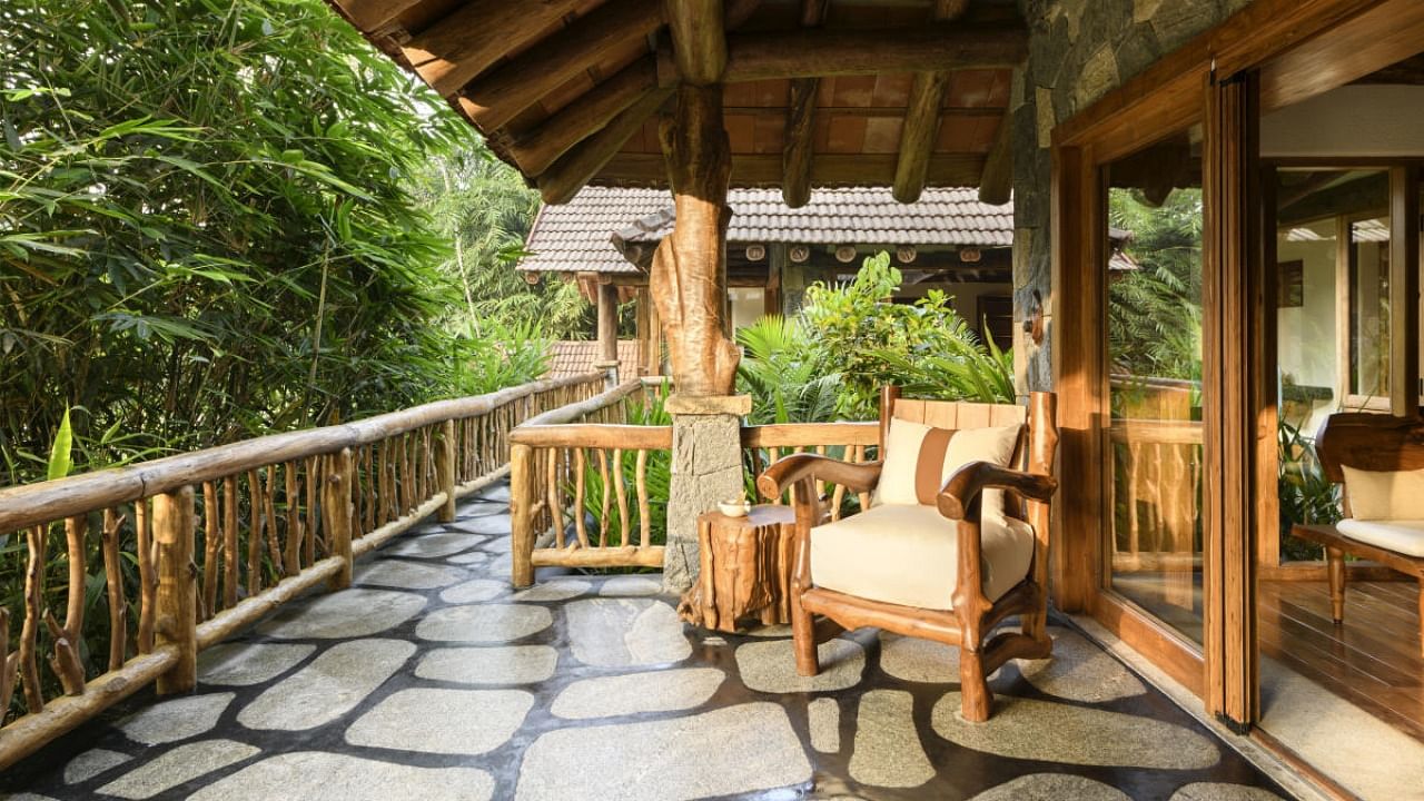 A balcony design at a Kalpetta residence featuring stone flooring with black oxide edges, designed by Bengaluru-based company Earthitects.