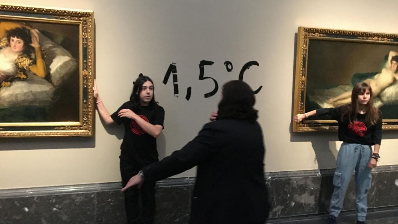 Protestors stick themselves to Goya's paintings "Las maja naked" and "La maja ropa" to alert about the climate emergency in Madrid. Credit: Reuters Photo