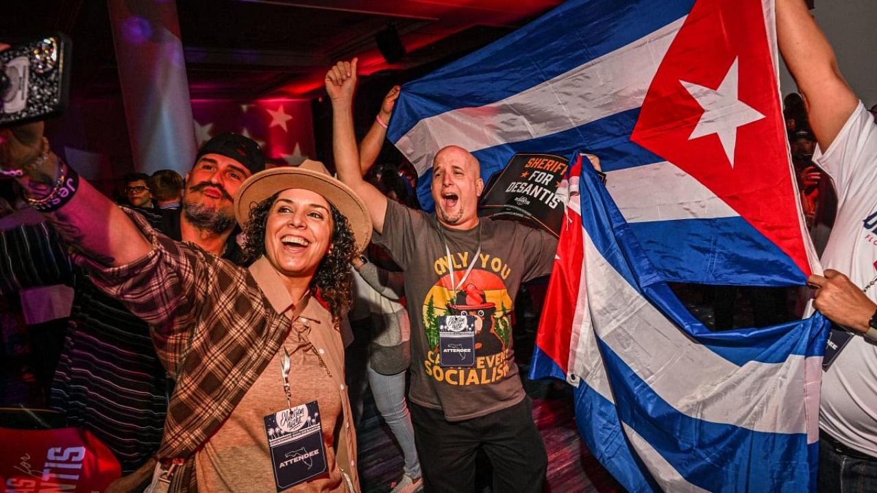 Supporters of Republican gubernatorial candidate for Florida Ron DeSantis cheer and wave Cuban flags during an election night watch party at the Convention Center in Tampa, Florida. Credit: AFP Photo