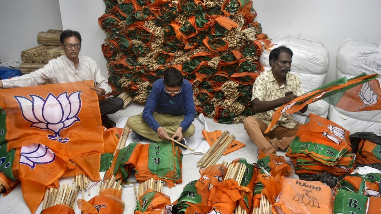 Bharatiya Janata Party (BJP) workers prepare party flags for campaigning ahead of Gujarat Assembly elections, in Rajkot. Credit: PTI Photo