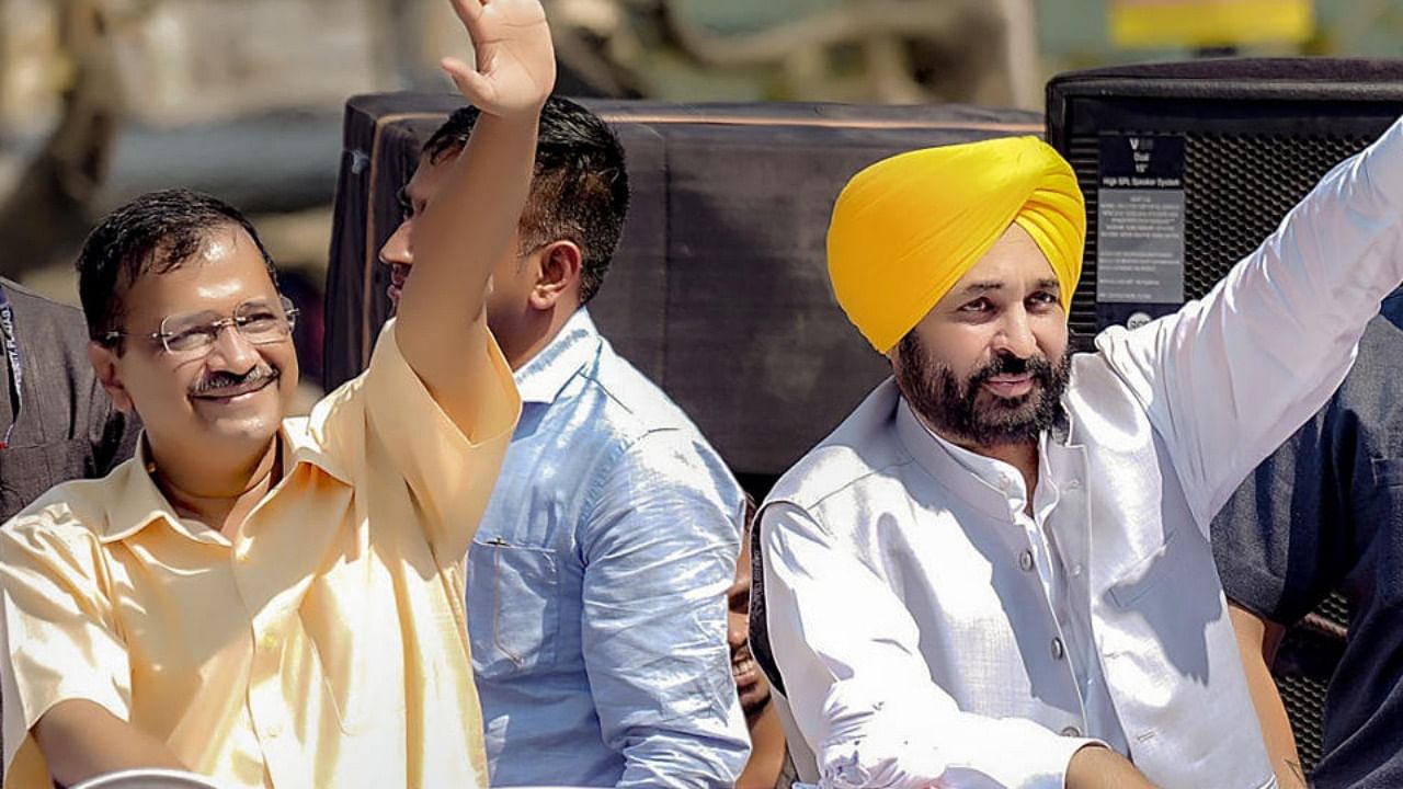 Punjab Chief Minister Bhagwant Mann and Delhi Chief Minister Arvind Kejriwal wave at the supporters during a roadshow representing Aam Aadmi Party (AAP), in Mandi. Credit: PTI Photo