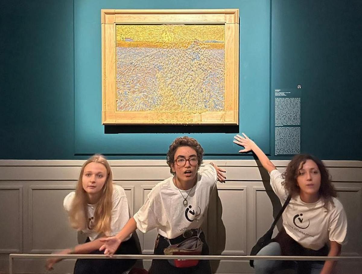 Climate activists pose in front of ‘The Sower’, an 1888 painting by Dutch artist Vincent Van Gogh displayed at Rome’s Palazzo Bonaparte after they threw pea soup at it. (AFP)