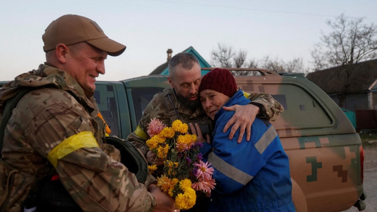 Local resident Valentyna Buhaiova embraces Ukrainian marines in the recently retaken village of Kyselivka, outside of Kherson. Credit: Reuters Photo