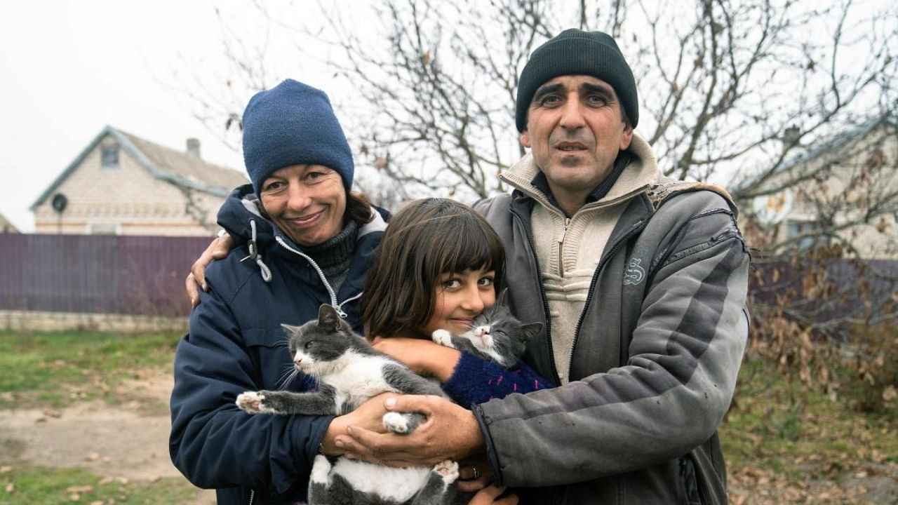 Viktor Galak (R) and his wife Svitlana (L) and their 10-year-old daughter Anna in the liberated village of Pravdyne, Kherson. Photo Credit: AFP Photo