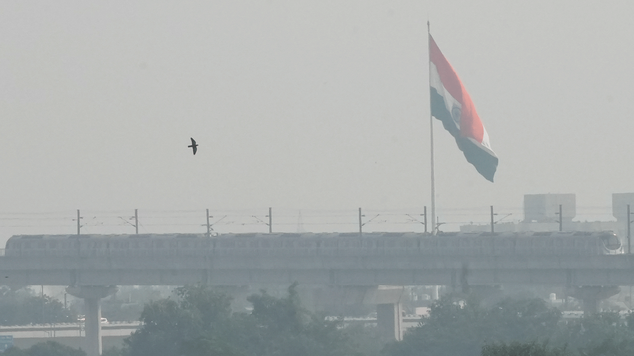 A metro train crosses over the Yamuna river amid low visibility due to smog, in New Delhi. Credit: PTI Photo