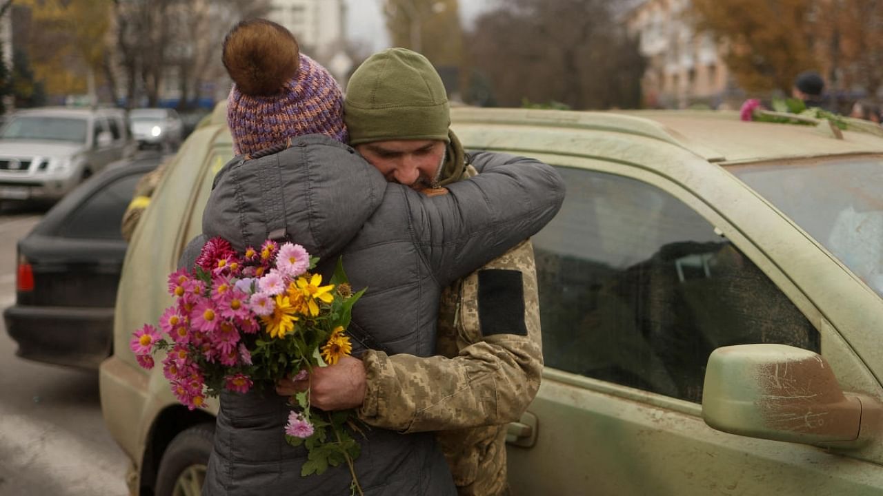 A local resident hugs a Ukrainian serviceman after Russia's retreat from Kherson, in central Kherson, Ukraine November 13, 2022. Credit: Reuters Photo