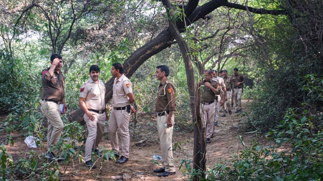 Police personnel look for evidence in the Mehrauli forest area. Credit: PTI Photo