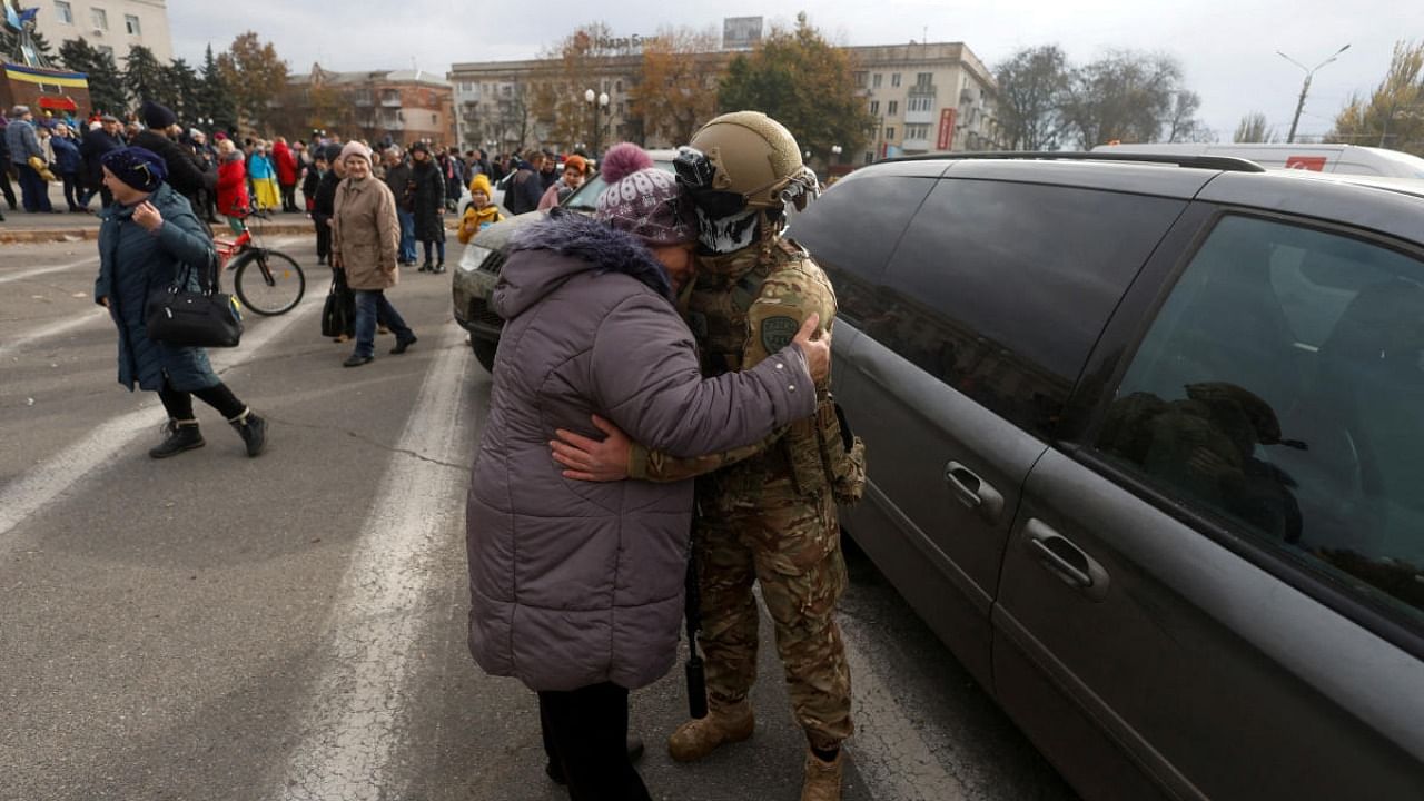 A woman embraces a Ukrainian service member in the city centre after Russia's retreat from Kherson, Ukraine. Credit: Reuters photo