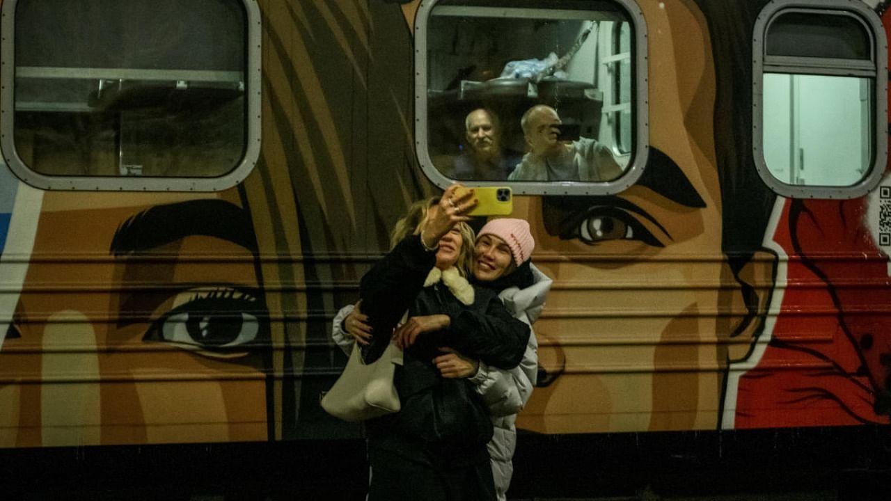 People take selfies in front of the first train to travel to liberated Kherson, as Russia's attack on Ukraine continues, in Kyiv. Credit: Reuters photo