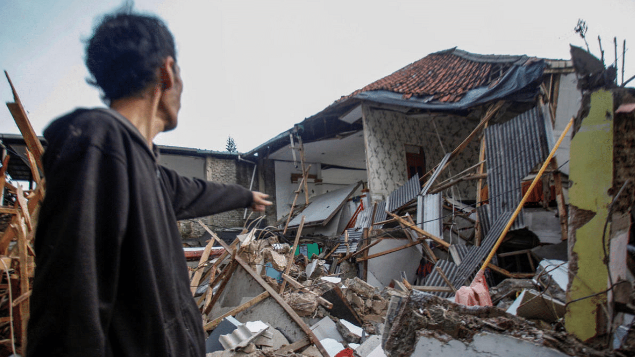 A local stands near houses damaged after earthquake hit in Cianjur, West Java province, Indonesia. Credit: Reuters Photo