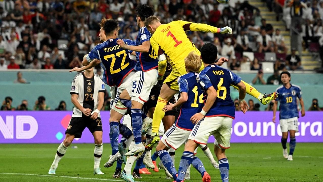 Germany's goalkeeper #01 Manuel Neuer (C) and players jump for the ball on the goal area of Japan during the Qatar 2022 World Cup. Credit: AFP Photo