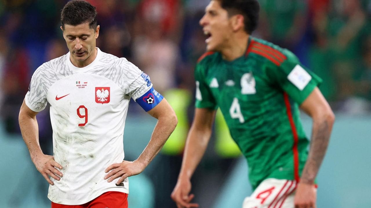 Poland's Robert Lewandowski looks dejected after having a penalty kick saved by Mexico's Guillermo Ochoa as Edson Alvarez celebrates. Credit: Reuters Photo