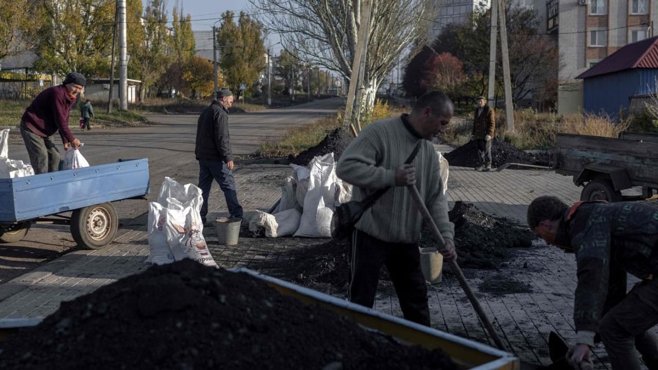 Ukrainian residents load a small truck with coal to distribute among people for the winter preparations. Photo Credit: AFP 