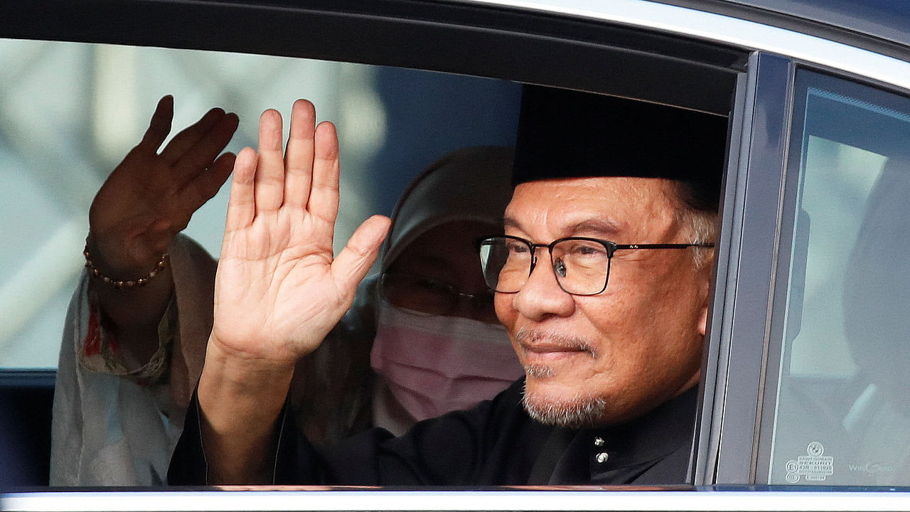 Malaysian new Prime Minister Anwar Ibrahim waves at the photographer as he arrives at the National Palace in Kuala Lumpur. Credit: Fazry Ismail/Pool via Reuters Photo