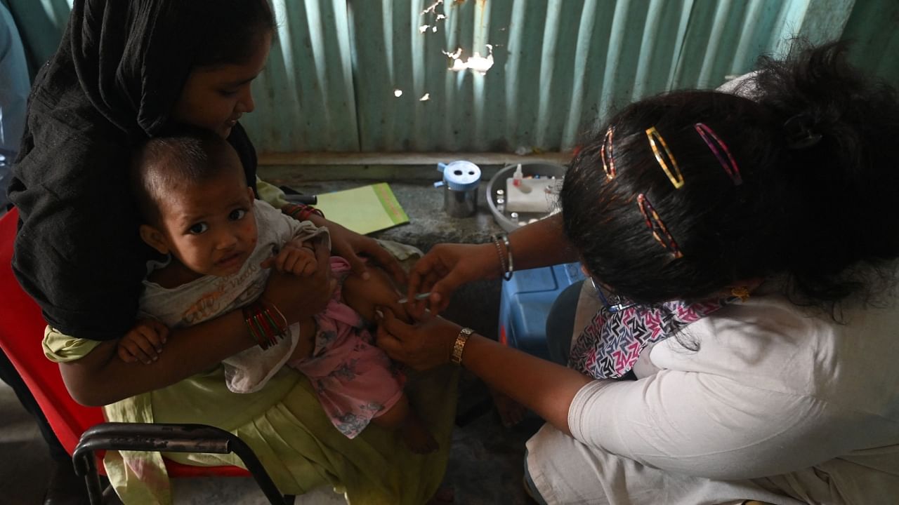 A health worker administers a vaccine to a child at a temporary vaccination camp following a measles outbreak that has caused the death of 10 children, in Mumbai on November 23, 2022. Credit: AFP Photo