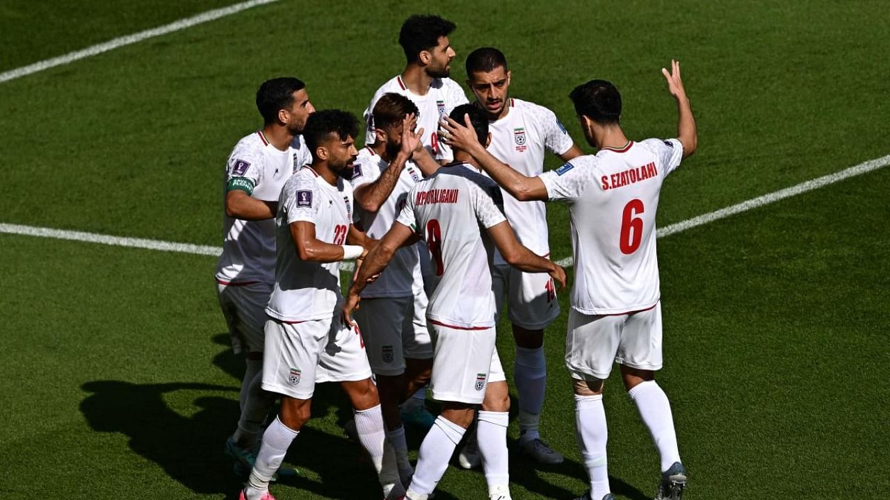 Iran's midfielder #17 Ali Gholizadeh celebrates with teammates after scoring a goal which was later disallowed during the Qatar 2022 World Cup Group B football match between Wales and Iran. Credit: AFP Photo