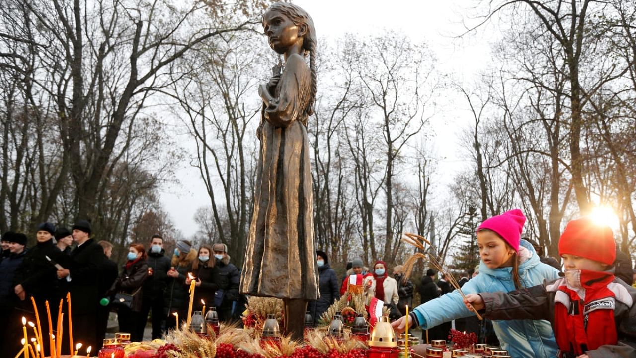 Children place ears of wheat as they visit a monument to Holodomor victims during a commemoration ceremony marking the 87th anniversary of the famine of 1932-33, in which millions died of hunger, in Kyiv, Ukraine. Credit: Reuters Photo