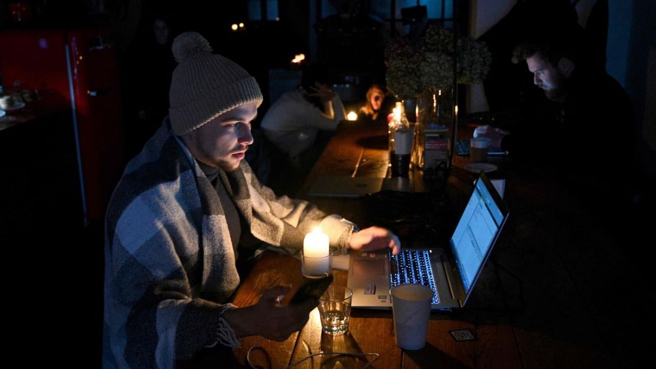 People rest in a coffee shop in Lviv as the city lives through a scheduled power outages on November 24, 2022, after the latest Russian massive airstrikes on the Ukrainian energy infrastructure, amid the Russian invasion in Ukraine. Credit: AFP Photo