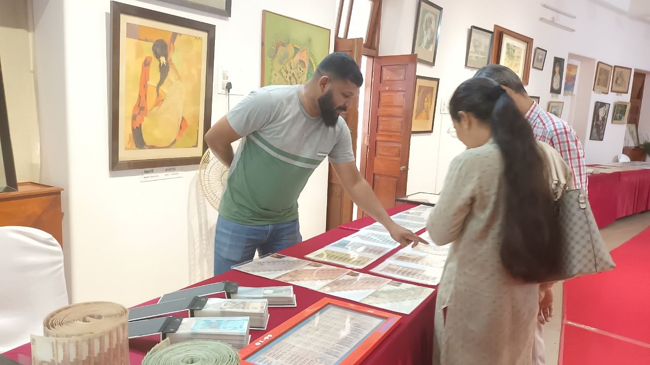 Numismatist Mohammed Yaseer explaining his collection of coins and currencies to visitors during an exhibition held at Srimanthi Bai Memorial Government Museum in Bejai on Friday. Credit: DH Photo