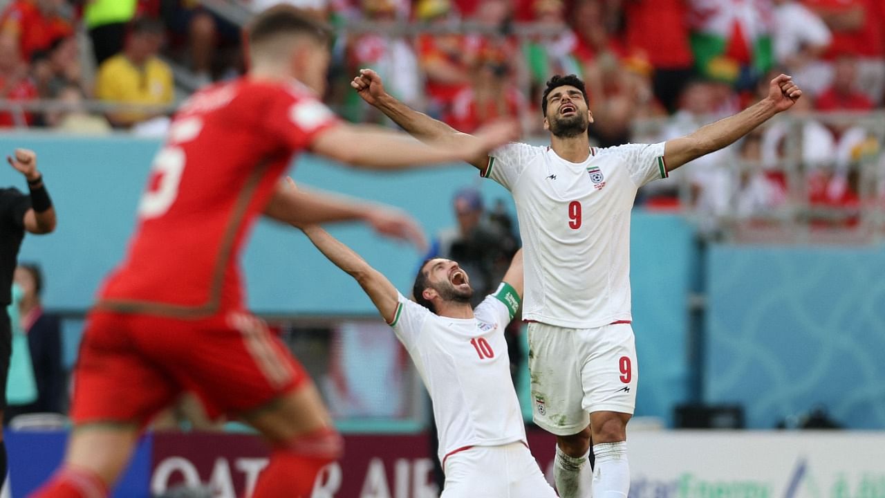  Iran's forward #09 Mehdi Taremi and Iran's forward #10 Karim Ansarifard react following their victory during the Qatar 2022 World Cup. Credit: AFP Photo