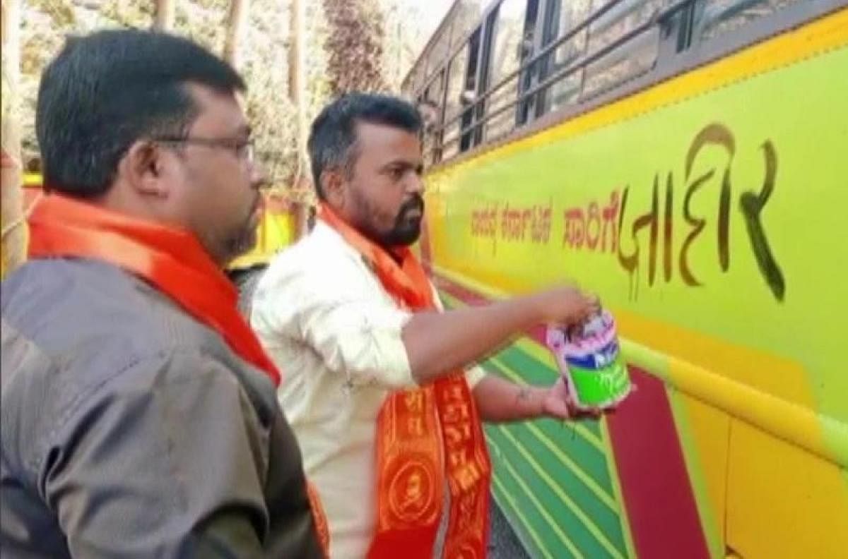 Marathi activists write anti-Karnataka graffiti on a NWKRTC bus at Daund near Pune on Friday. Credit: DH Photo