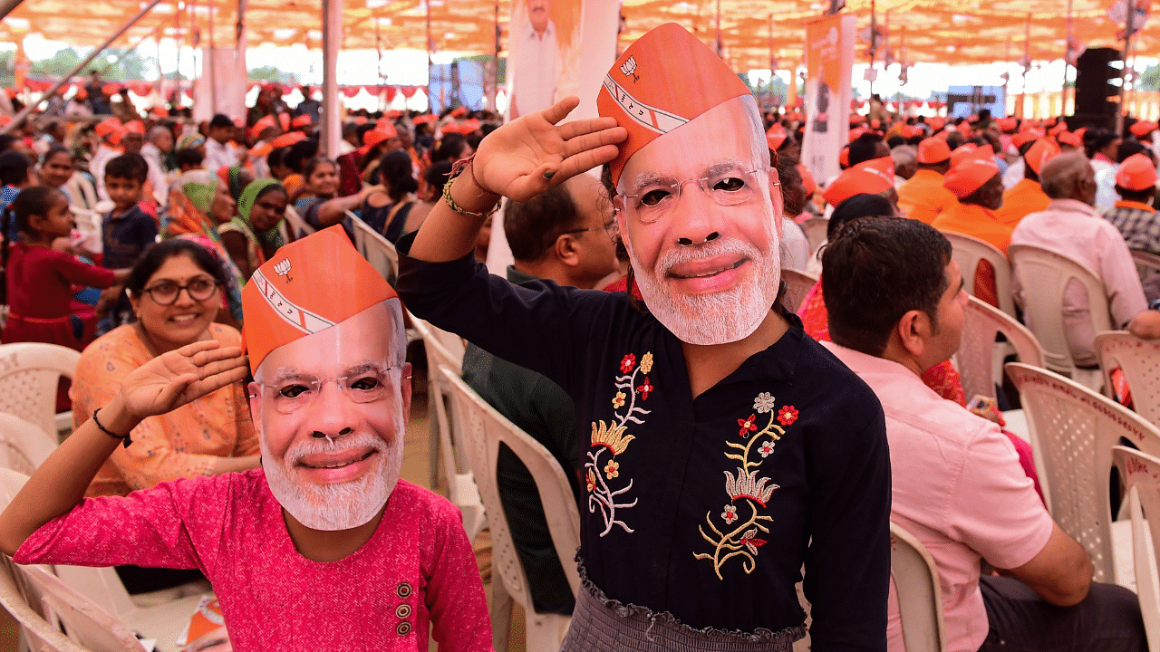 Supporters of BJP cheer during a rally to be addressed by PM Narendra Modi. Credit: AFP Photo