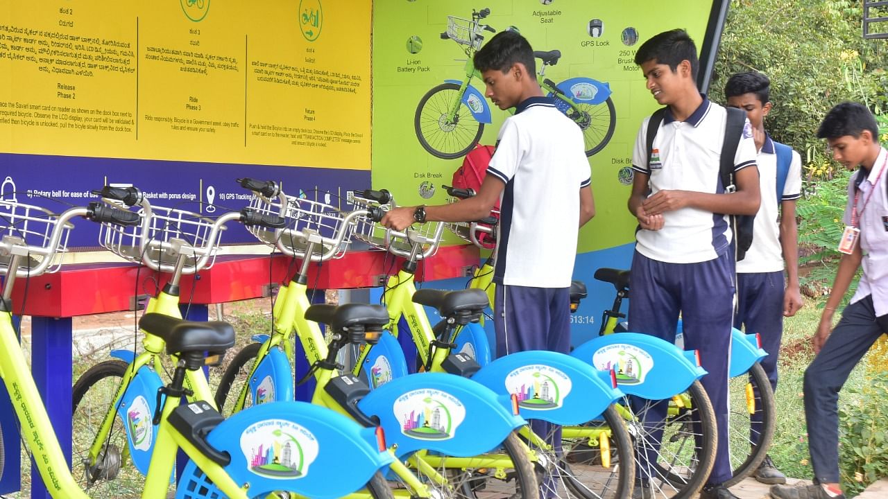 Students show keen interest about the use of bicycles at ‘Savari’ PBS docking station at Akshay Colony in Hubballi. Credit: DH Photo