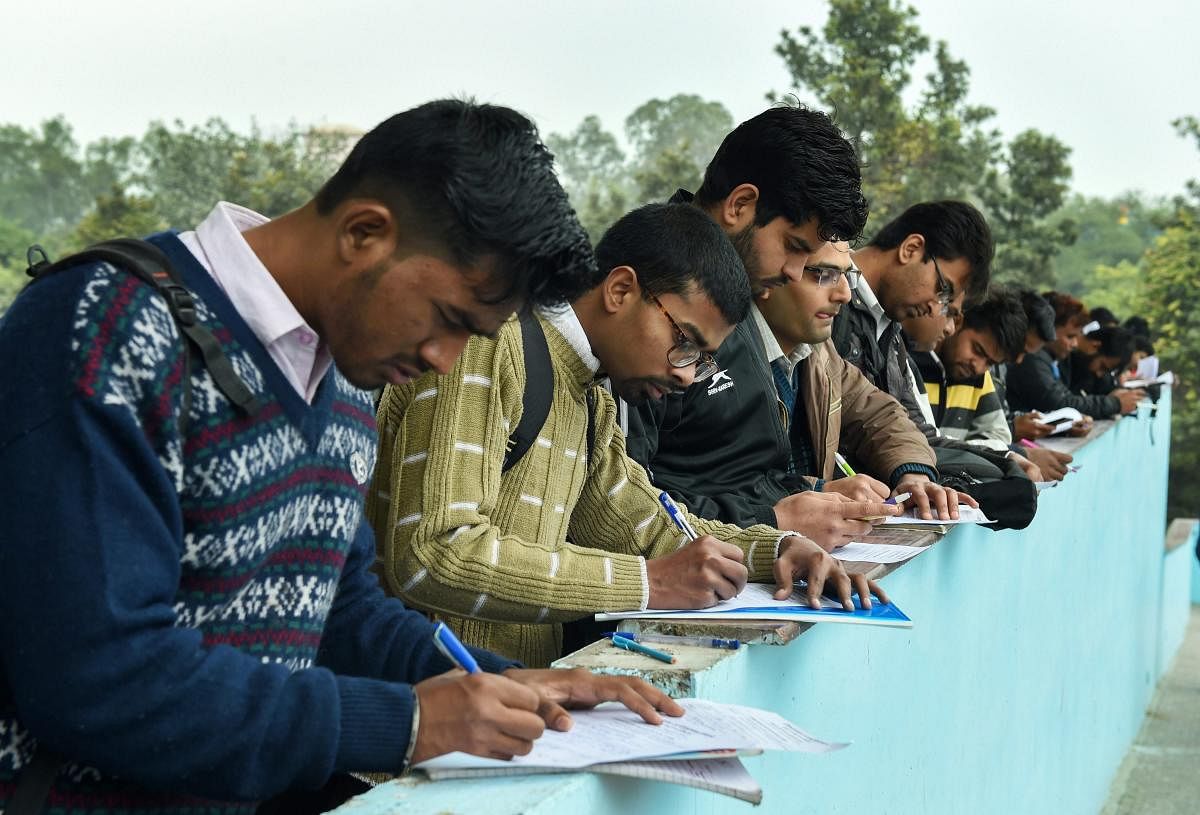Job seekers fill their registration forms during a job mela in Delhi. Credit: PTI Photo
