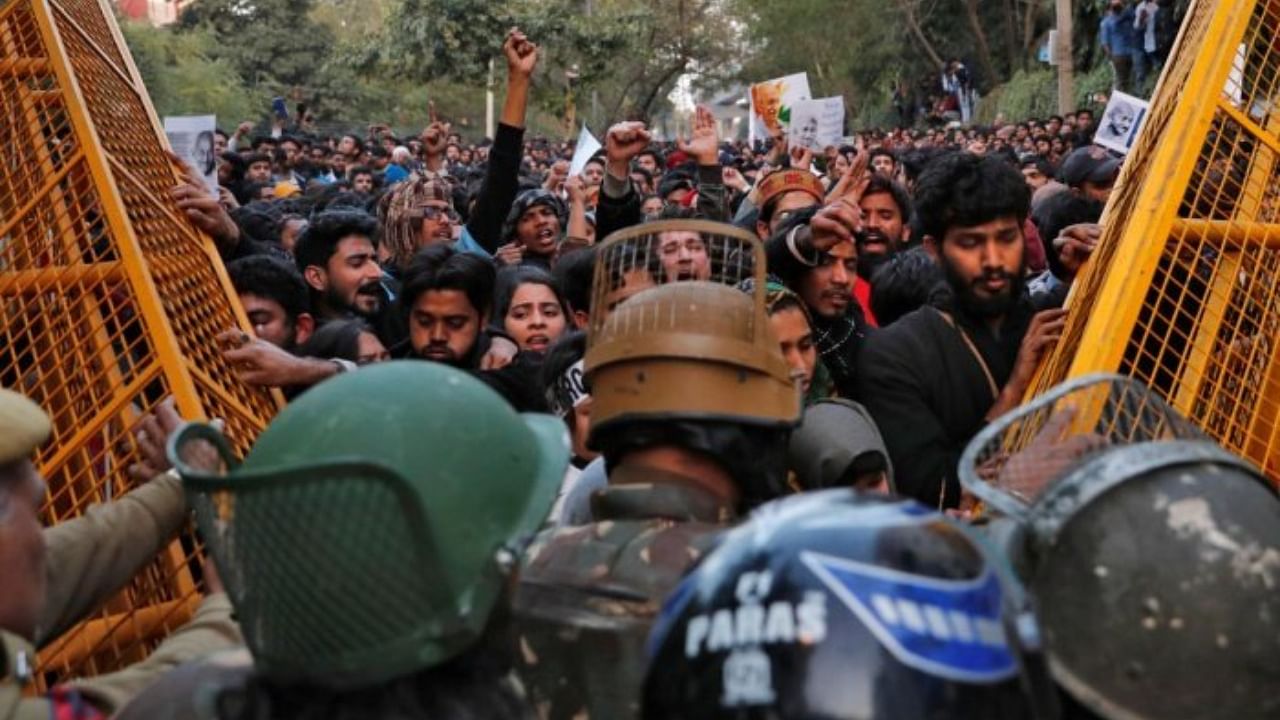Demonstrators try to remove police barricades during a protest against a new citizenship law outside the Jamia Millia Islamia university in New Delhi. Credit: Reuters Photo