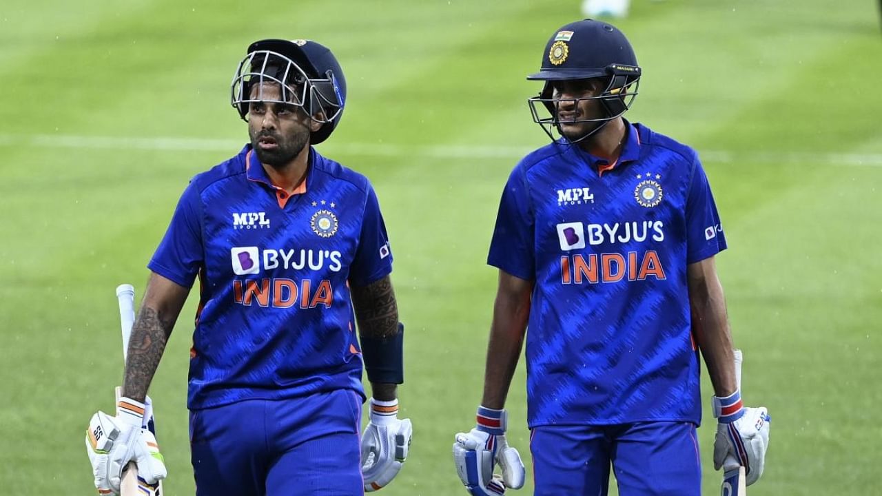 Suryakumar Yadav, left, and Shubman Gill leave the field during a rain delay during their one day international cricket match in Hamilton. Credit: AP/PTI Photo
