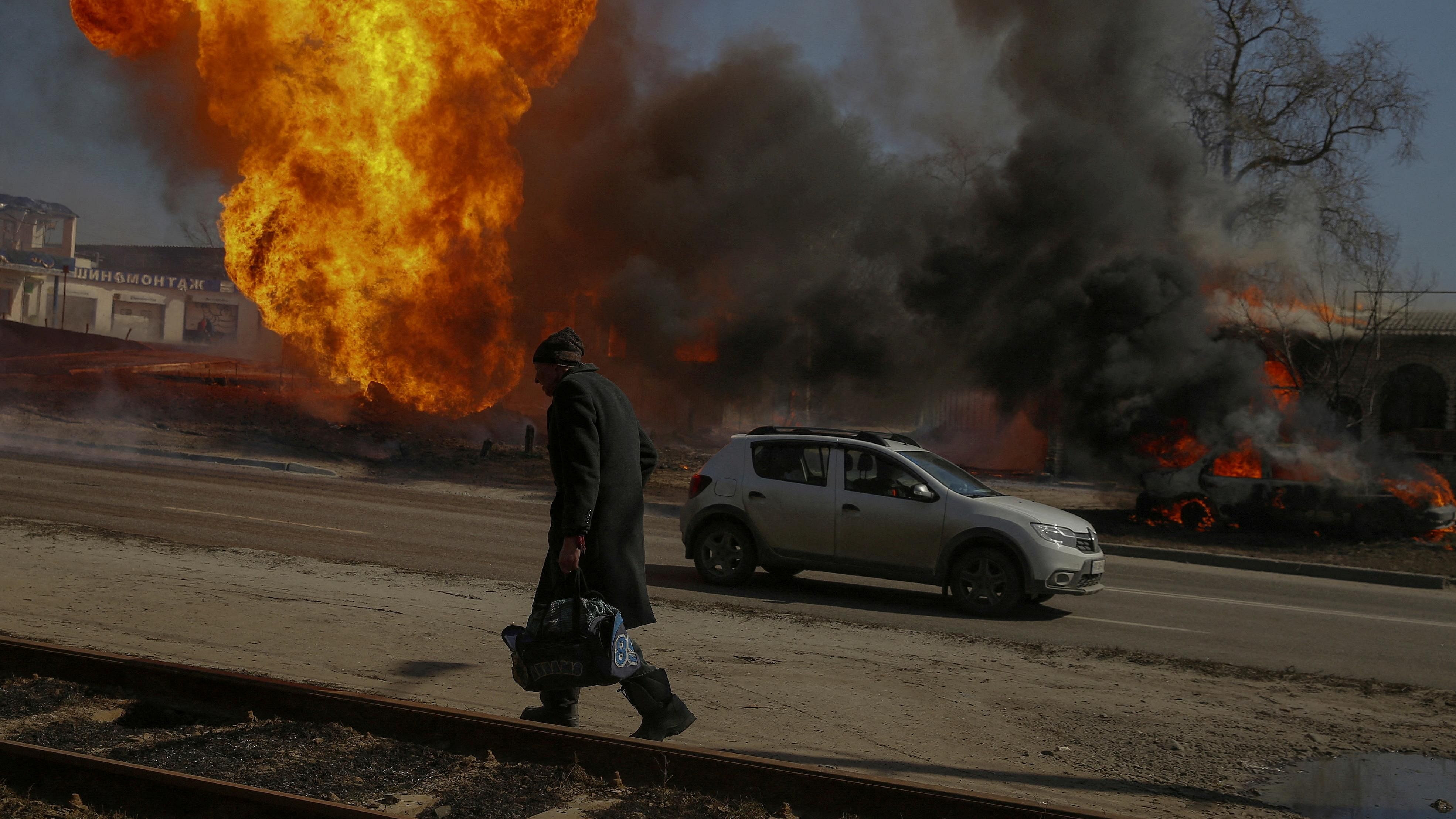 A man walks past a fire after a shelling, as Russia's attack on Ukraine continues, in Kharkiv. Credit: Reuters Photo