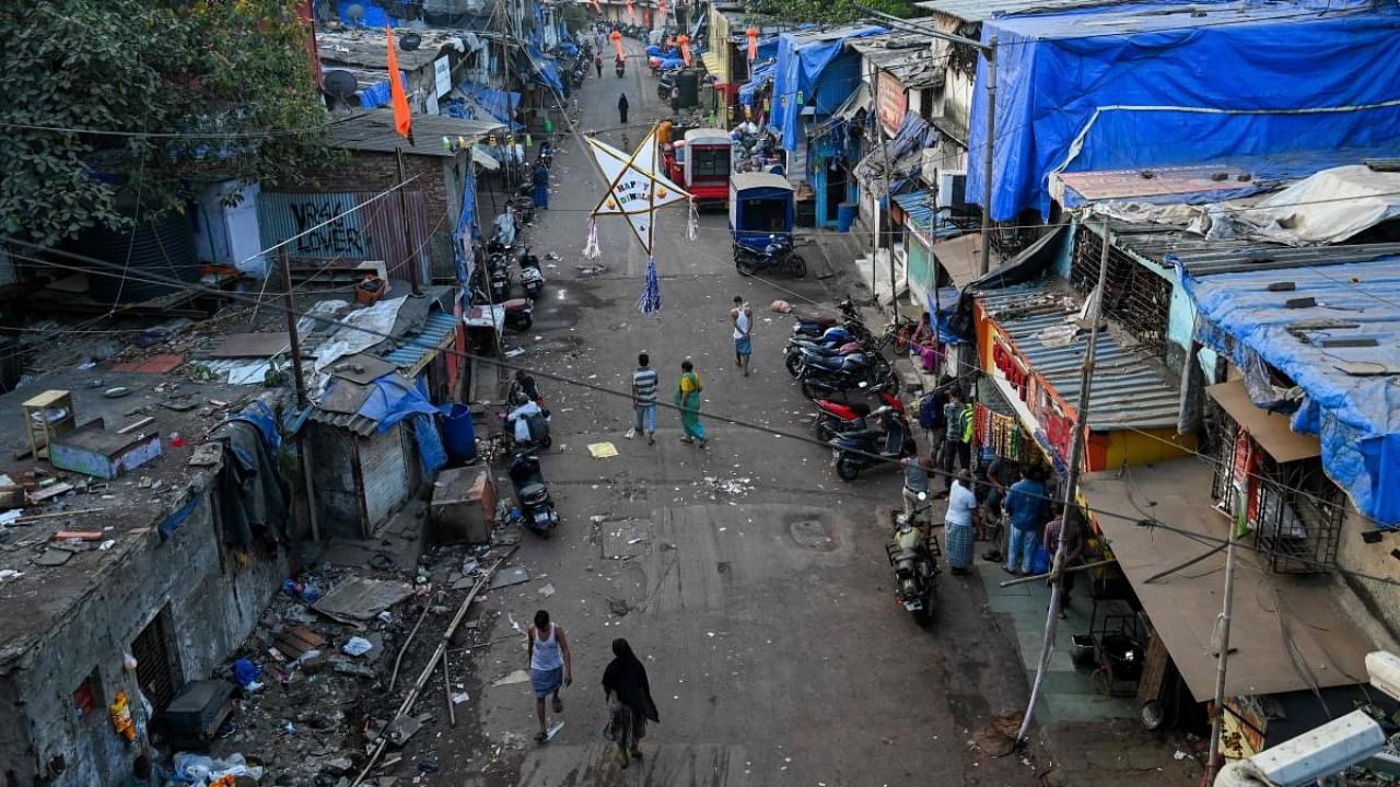In this photograph taken on November 2, 2022, residents walk through a street along the Dharavi slums during morning hours in Mumbai. Credit: AFP Photo