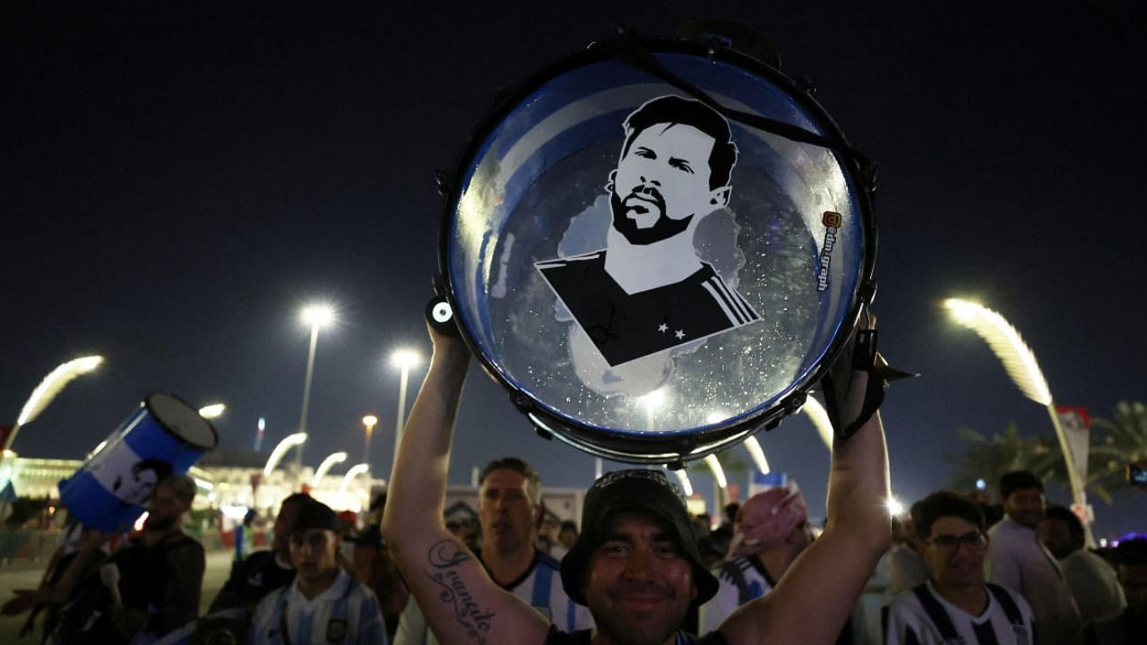 An Argentina fan holds up his drum with an image of Lionel Messi on it in Doha. Credit: Reuters Photo