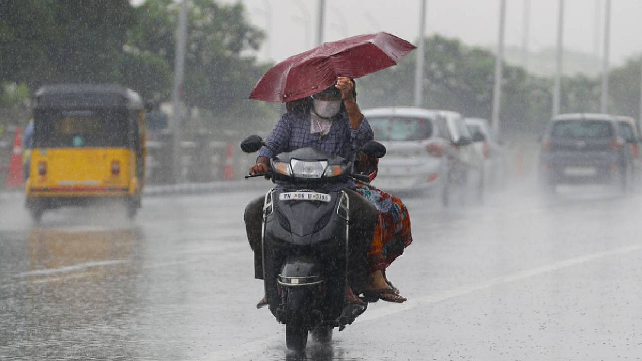 Commuters ride a two-wheeler amid incessant rainfall. Credit: PTI File Photo