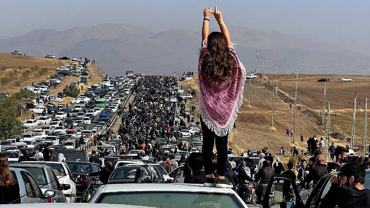 An unveiled woman standing on top of a vehicle as thousands make their way towards Aichi cemetery in Saqez, Mahsa Amini's home town in the western Iranian province of Kurdistan, to mark 40 days since her death, defying heightened security measures as part of a bloody crackdown on women-led protests. Credit: AFP Photo