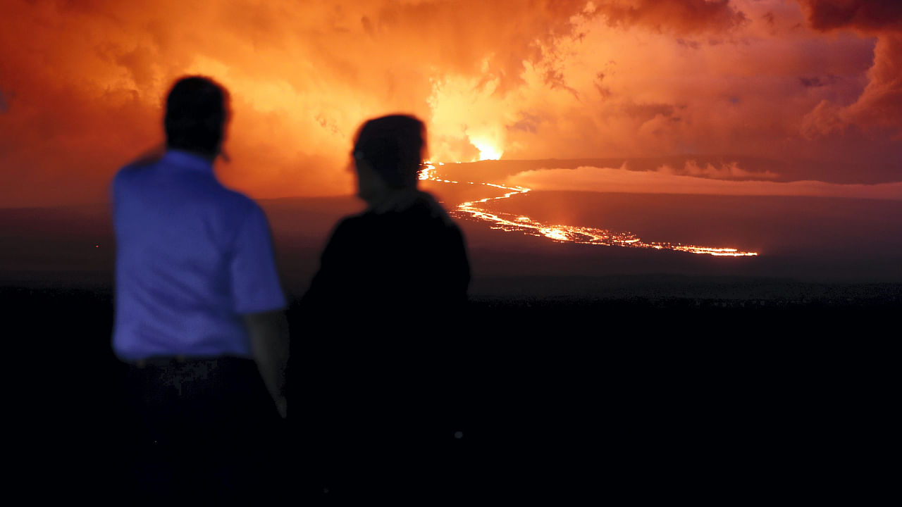 The smell of volcanic gases and sulfur was thick in the air Tuesday along Saddle Road, where people were watching a wide stream of lava creep closer. Credit: AP/PTI Photo