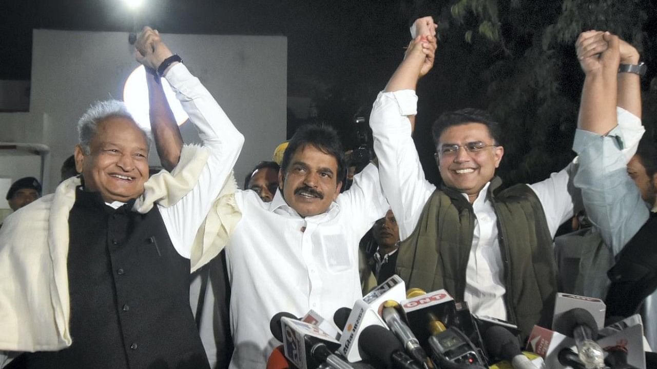 Congress General Secretary K C Venugopal raises his hands with Rajasthan Chief Minister Ashok Gehlot and party leader Sachin Pilot. Credit: PTI Photo
