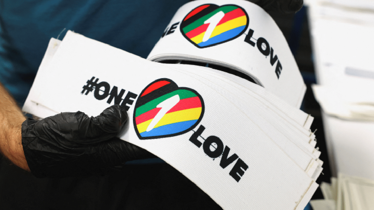 A worker carries One Love armbands, which are banned by FIFA at the World Cup Qatar 2022. Credit: Reuters Photo