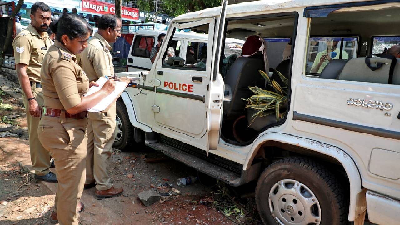 Police officers examine a vehicle that was damaged during a clash with protesters at a police station near the proposed Vizhinjam Port. Credit: Reuters Photo