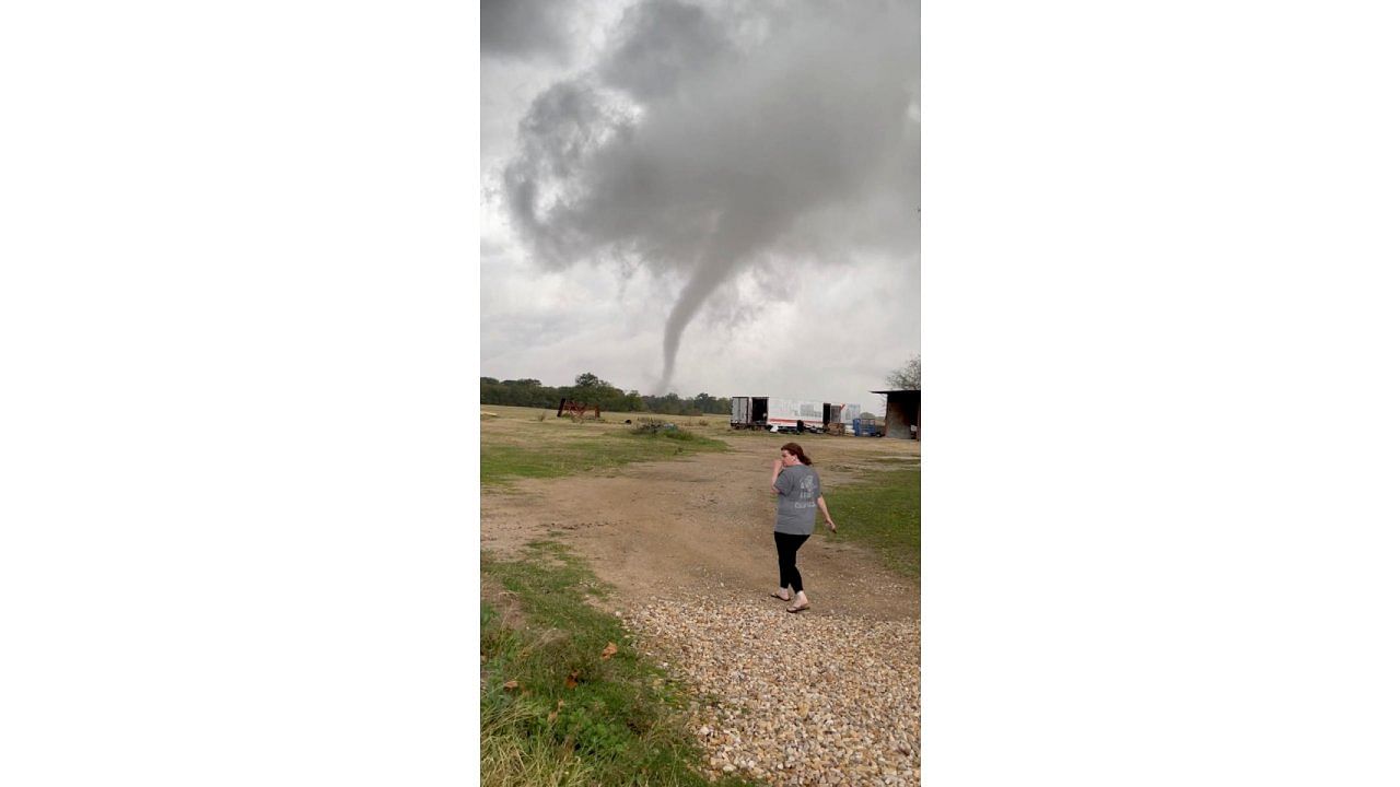 A woman walks in a farm as the funnel cloud of a tornado is seen in Greenview, Texas. Credit: Reuters File Photo