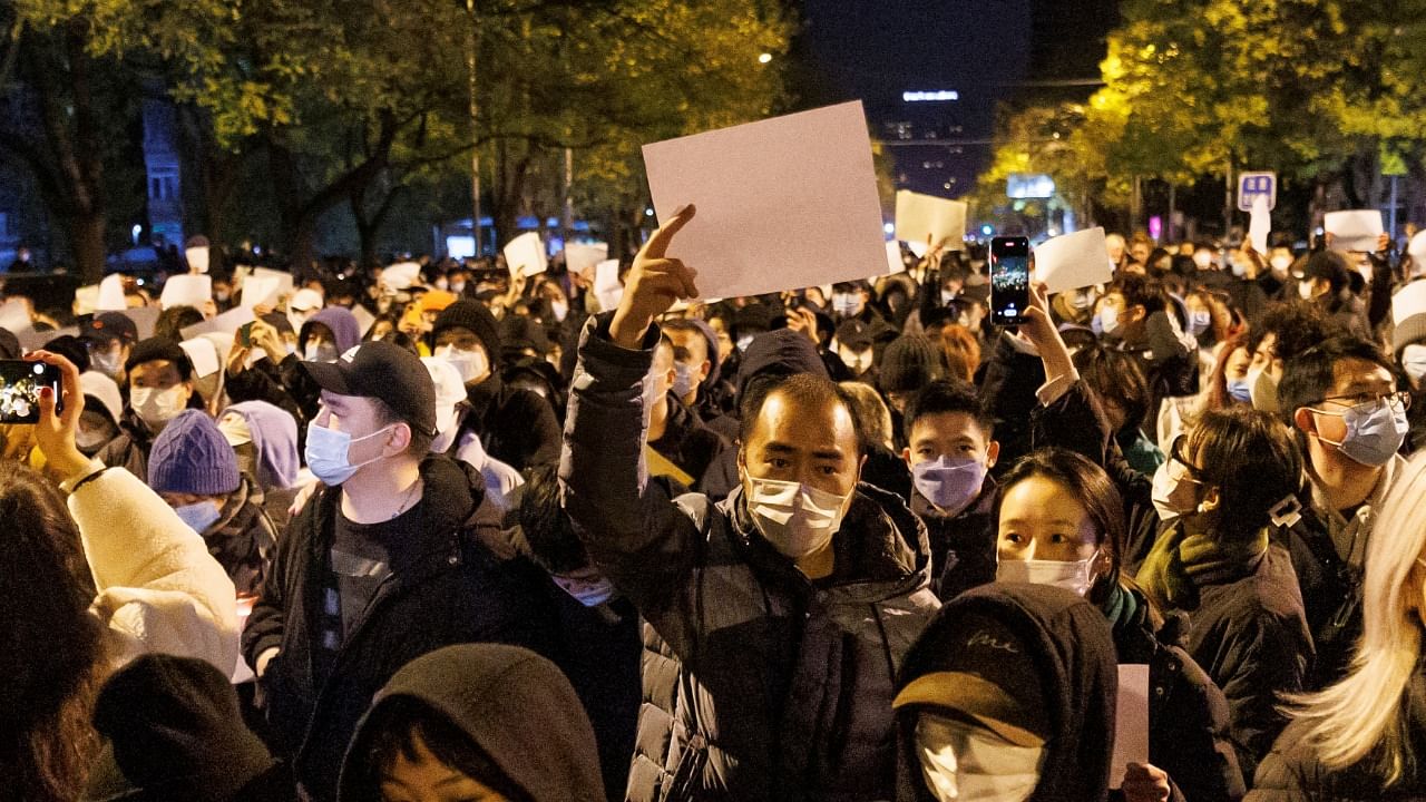 People hold white sheets of paper in protest of coronavirus disease (COVID-19) restrictions in Beijing. Credit: Reuters Photo