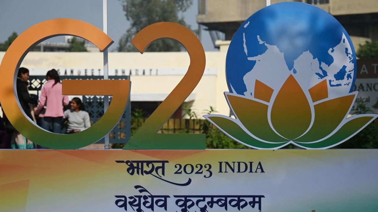 Children stand next to the G20 logo after its unveiling in New Delhi. Credit: AFP Photo