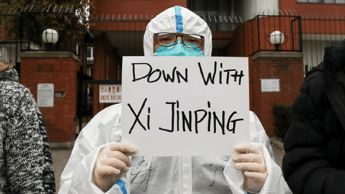 Protester in China holds a placard against Xi Jinping. Credit: Reuters Photo