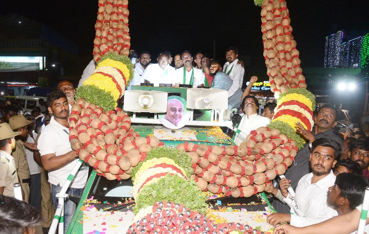 The JD(S) supporters welcome former chief minister and JDSLP leader H D Kumaraswamy with a copra garland weighing 250 kg during the Pancharatna Rathyatre in Tumakuru on Thursday. Credit: DH Photo
