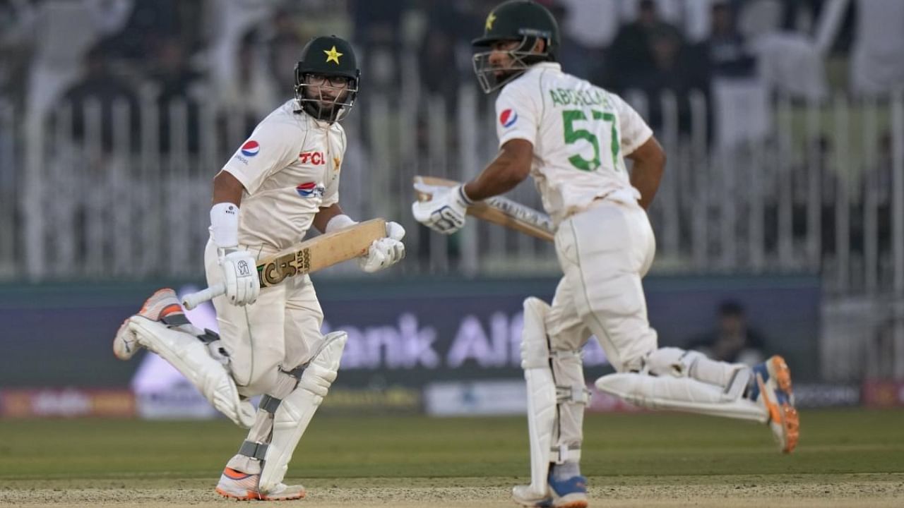Pakistan's Imam-ul-Haq, left, and Abdullah Shafique run between the wickets during the second day of the first test cricket match between Pakistan and England, in Rawalpindi, Pakistan, Friday, Dec. 2, 2022. Credit: AP/PTI