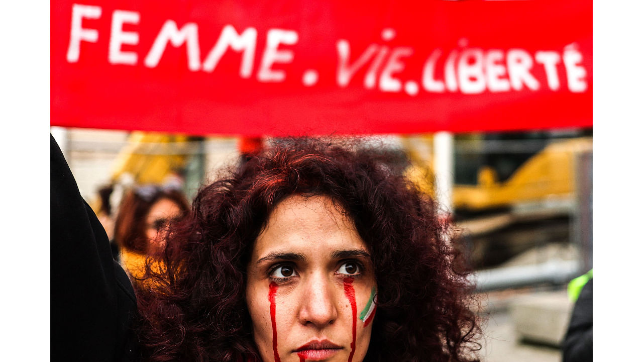A protestor with red tears painted on her face during a rally in support of the demonstrations in Iran, in Toulouse, south-western France, on December 3, 2022. Credit: AFP Photo