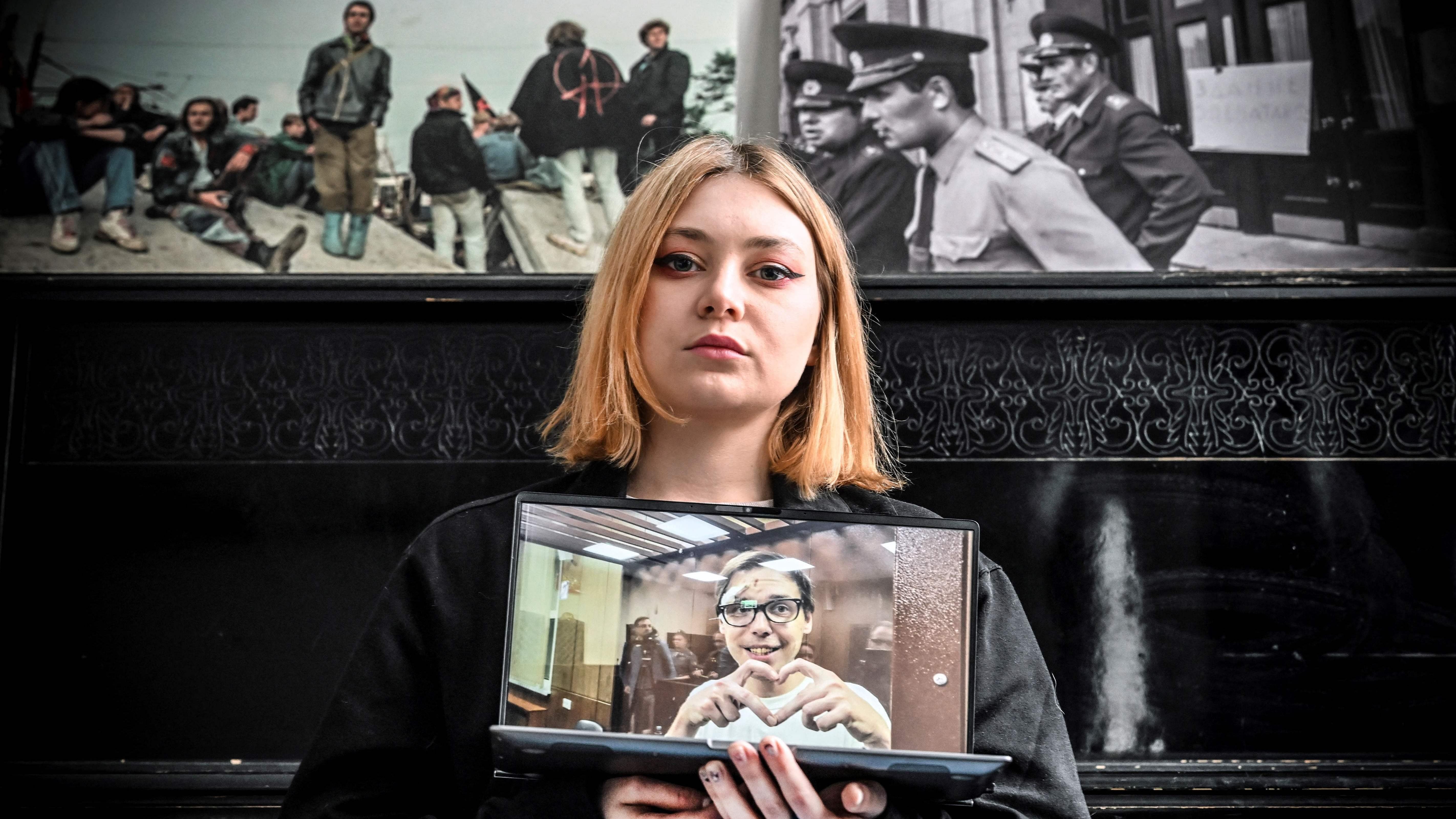 Alexanda Popova, 28, shows a photograph of her jailed friend Artyom Kamardin, 32. Credit: AFP Photo