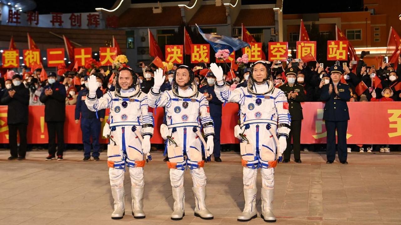(From R) Chinese astronauts Fei Junlong, Deng Qingming and Zhang Lu, crew of the Shenzhou-15 spaceflight mission, wave during a ceremony prior to the launch of the Shenzhou-15 mission at the Jiuquan Satellite Launch Center in Northwest China’s Gansu Province on November 29, 2022. Credit: AFP Photo